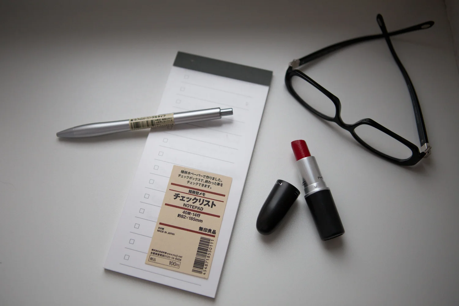 MUJI pen and paper , lipstick , & glasses.