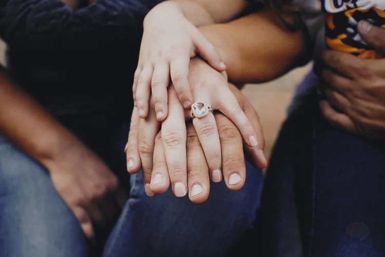 Wedding rings on the couple's joined hands.