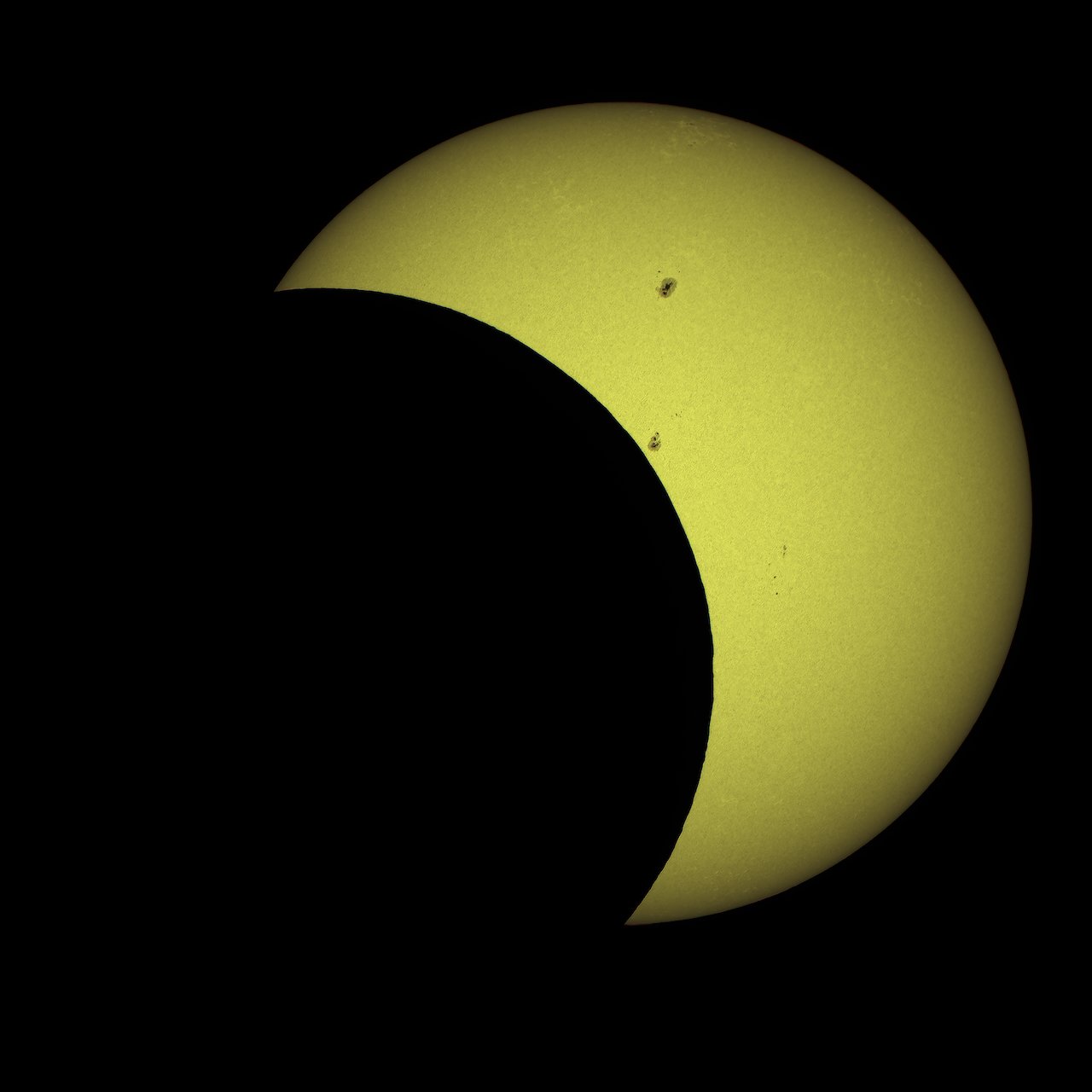 A partial solar eclipse showing two active sunspot regions