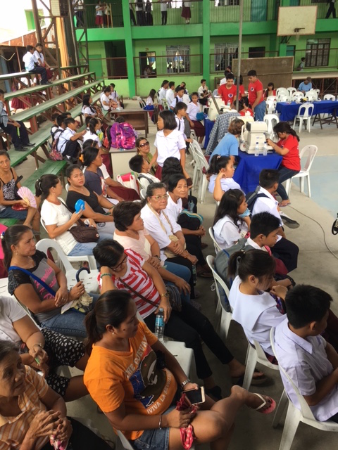 Adults and students waiting to get pretested before seeing the eye doctors. 