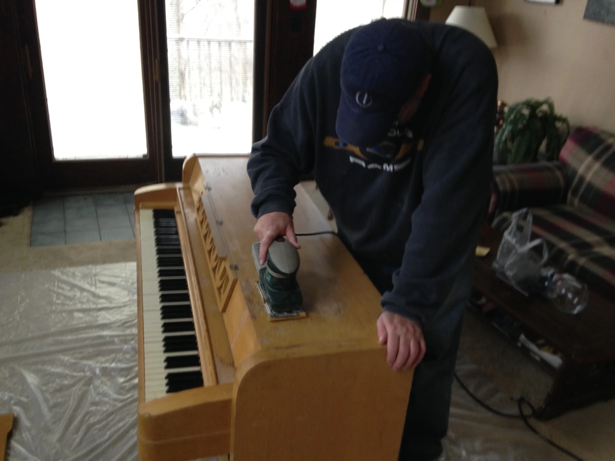 My father working on sanding off the original finish. 