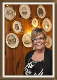 Jeanne in front of plates from local churches donated by patrons. The previous owner collected plates from all over the world. Inspired by that collection people contribute their own and are featured all over the restaurant.