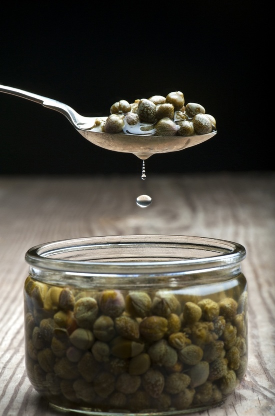 glass jar of capers spooned out