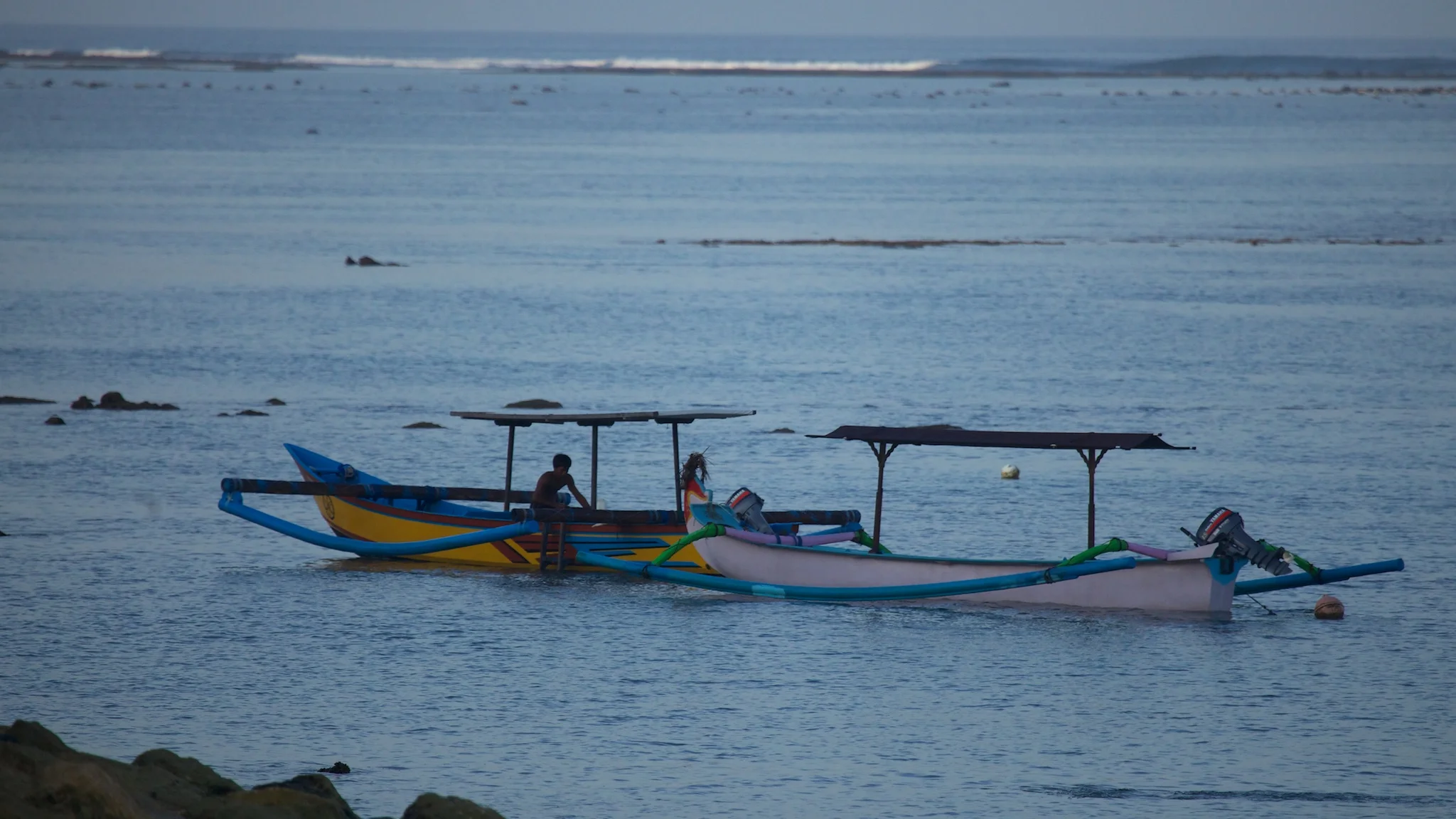 A couple of small boats, anchored just off the beach.