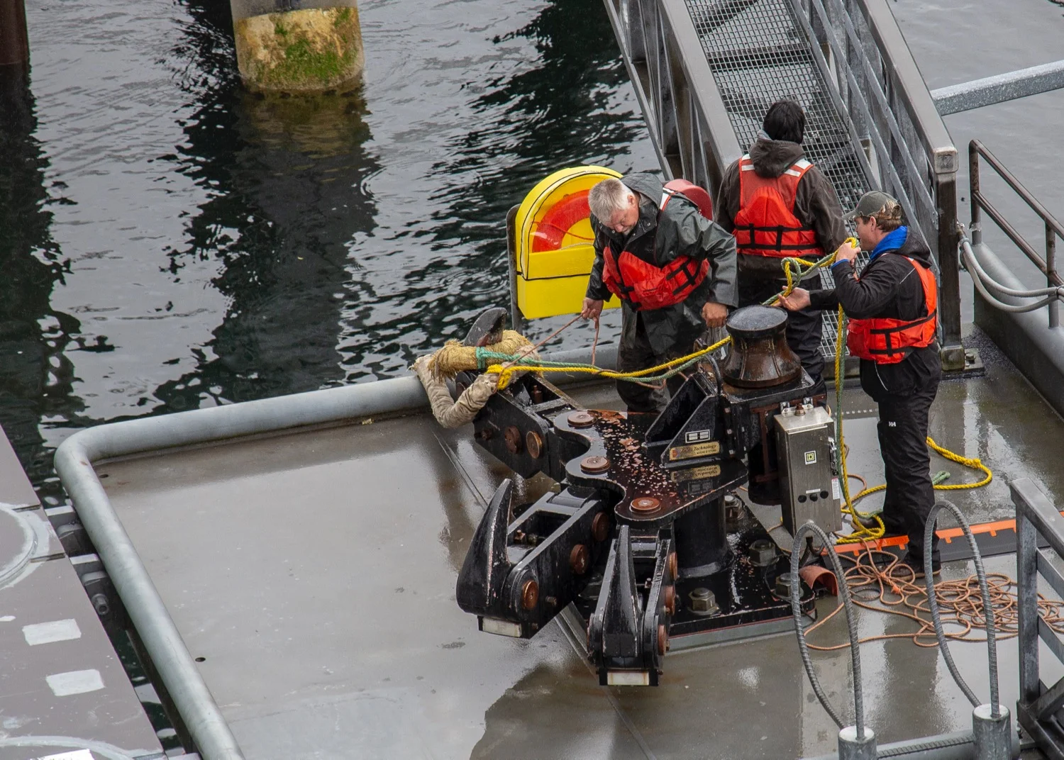 The huge ropes from the ship, being pulled up by teams of three people.