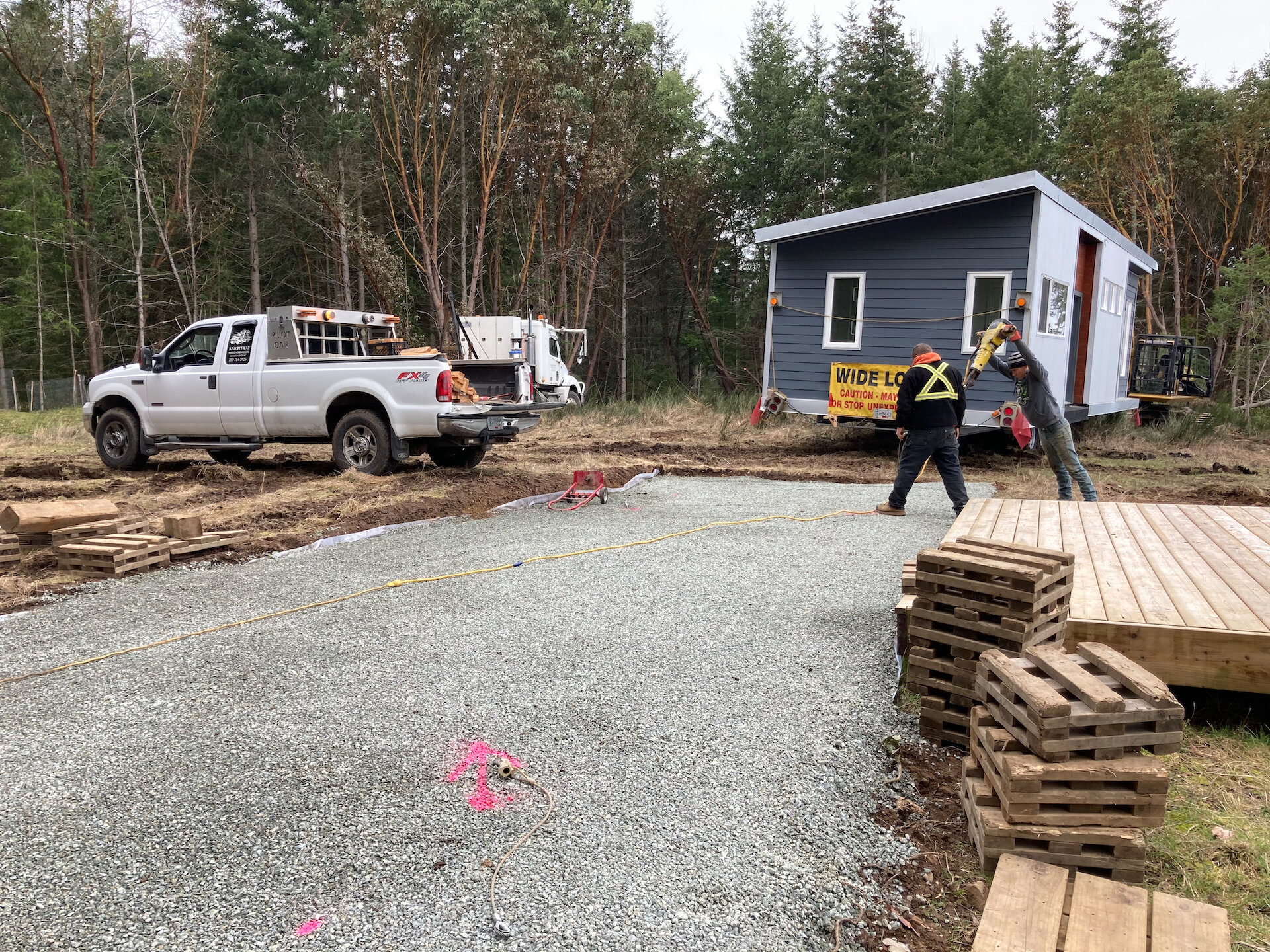  The pink spray paint is where they installed the seismic tie-downs. The guys in the background are using a long jackhammer to to drive “harpoons” 3’ into the ground for added stabilization.  