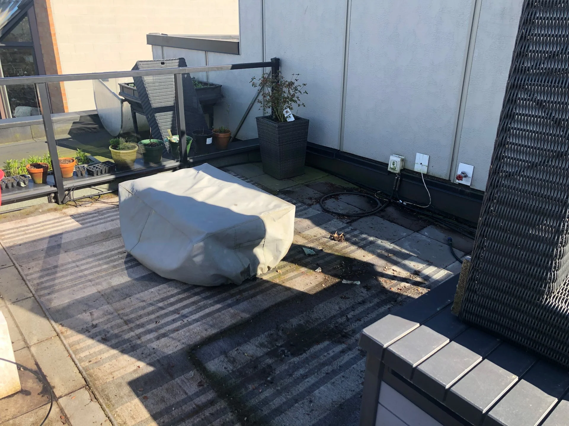 First step was to remove the sofa (thankfully it’s modular) and then the fire table so we could pull up the old rug and then pressure wash.