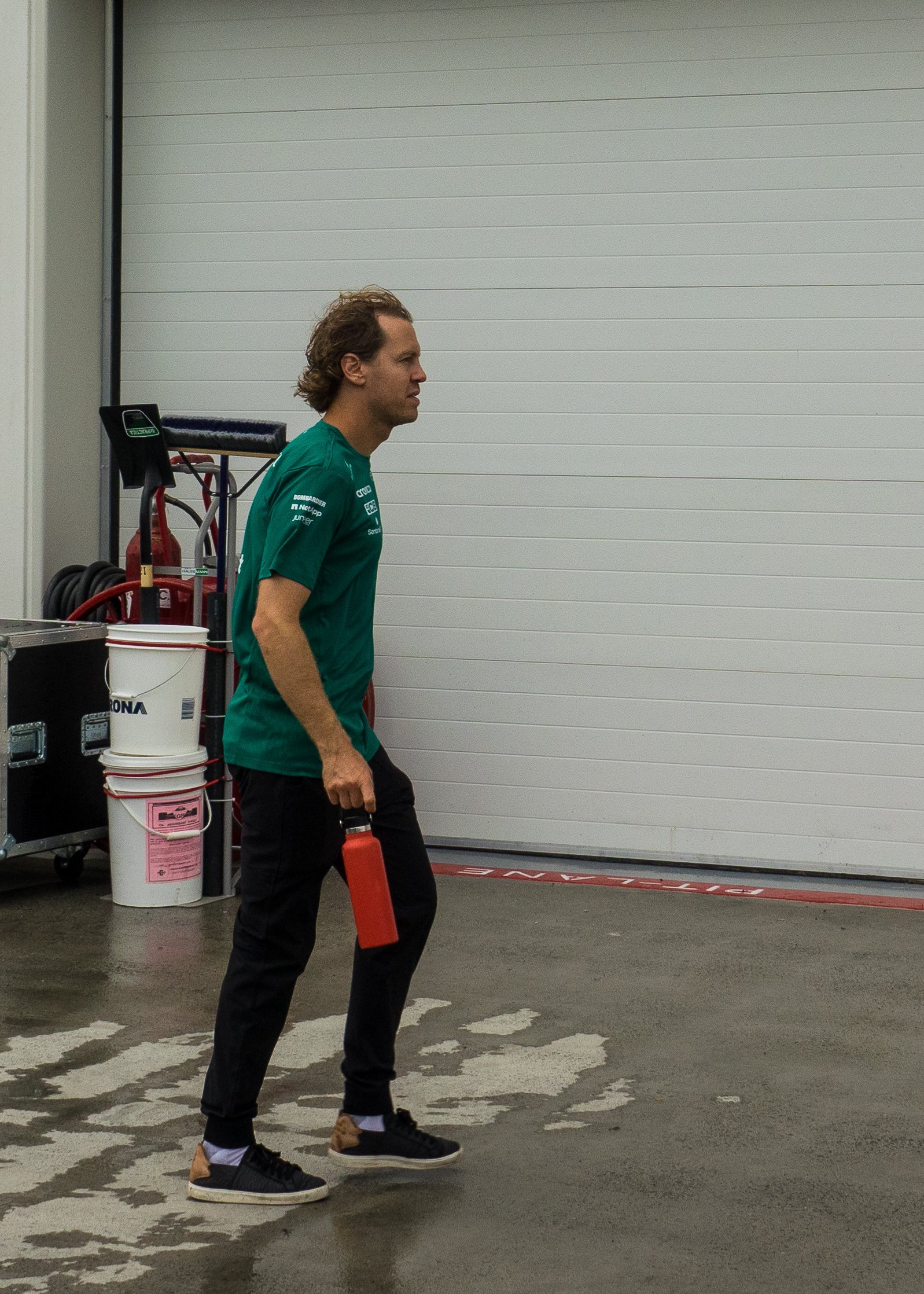  Sebastian Vettel heading into the Aston Martin garage.   