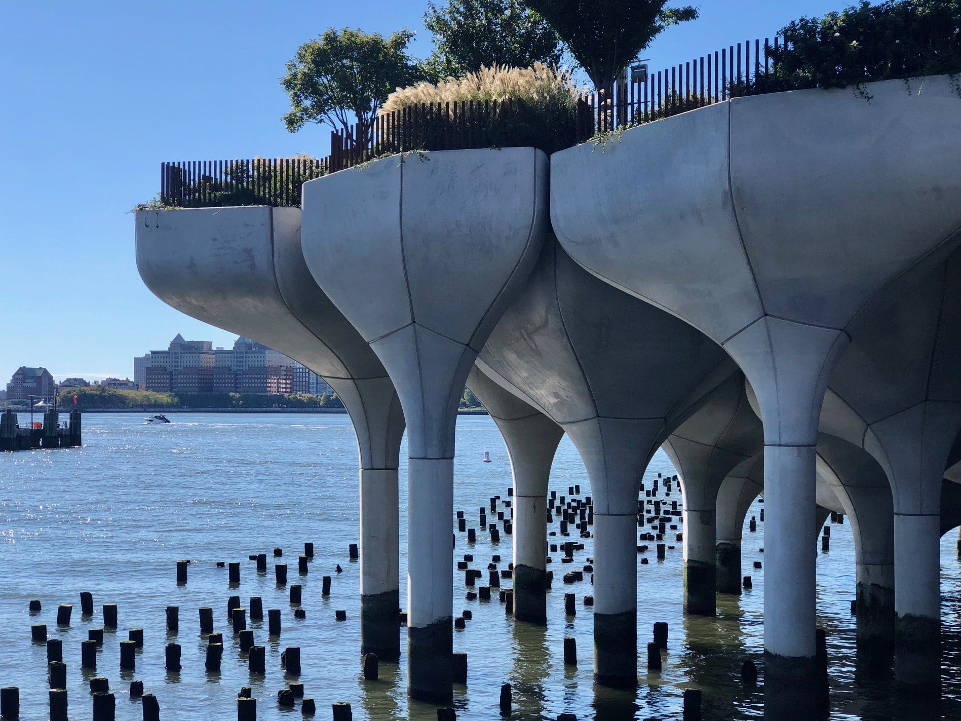  The new structures of the island sit amongst the pillars of older piers in the river. 