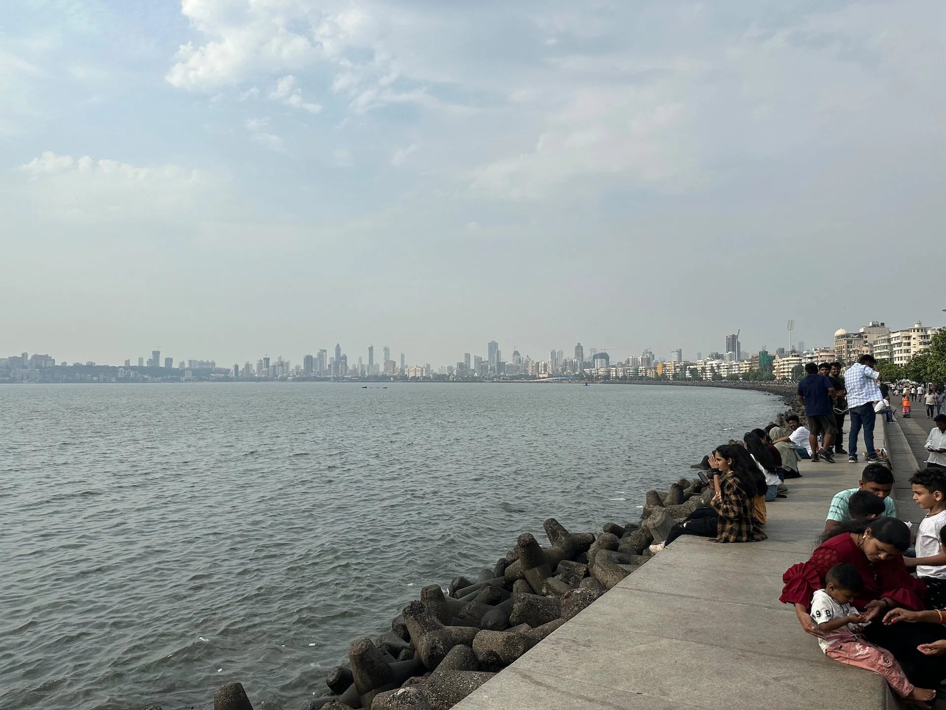  Sitting on the boardwalk along Marine Drive. You can see how far the Mumbai skyline continues to extend out into the distance.  