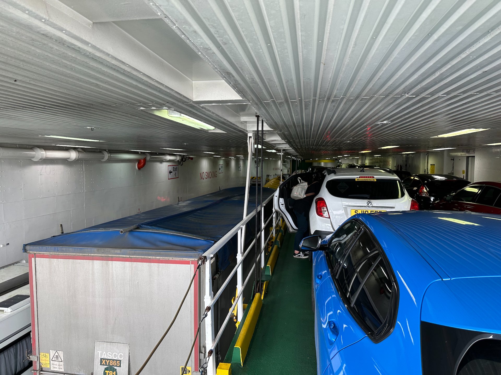  We were parked up on this ramp that they raised up in the air after loading all the cars, allowing them to put another row underneath, and the big trucks beside us. 