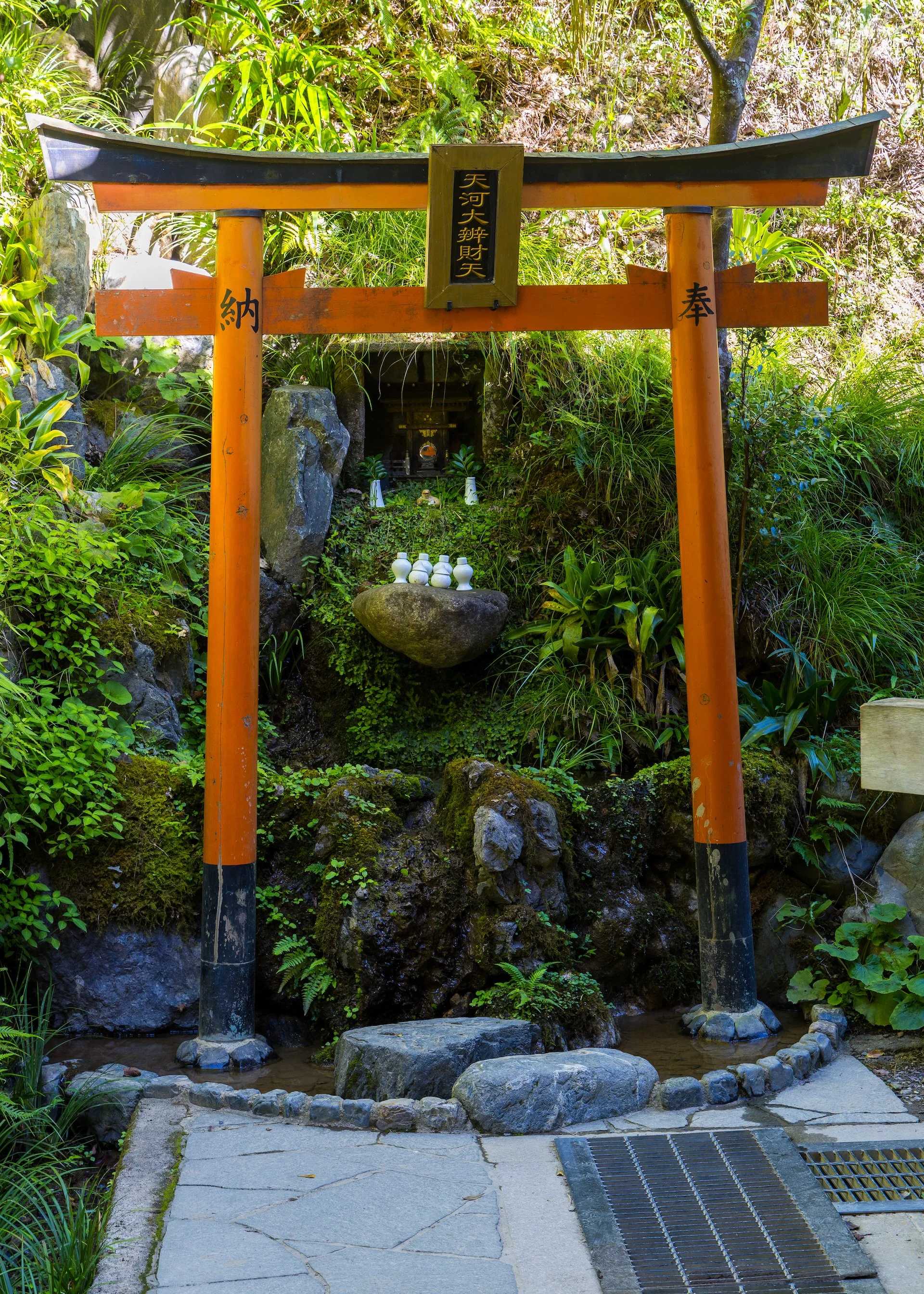  A torii gate in front of a small shrine. 