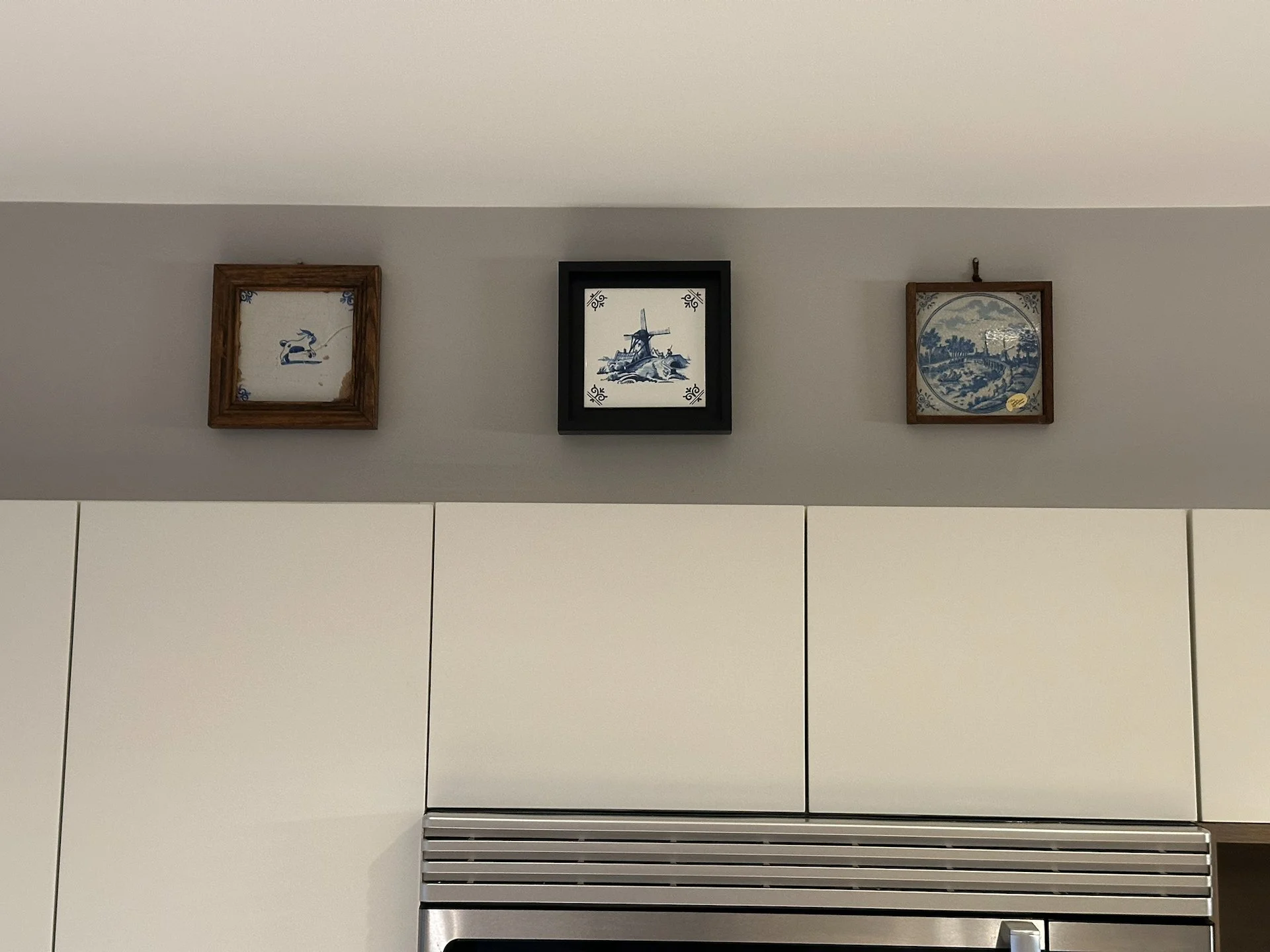  The cabinets don’t actually look much different. You can tell the quality is better, but they are pretty much the same. We decided to put our tiles up above them. The center one I bought in Delft on our Netherlands trip last year; the one of the lef