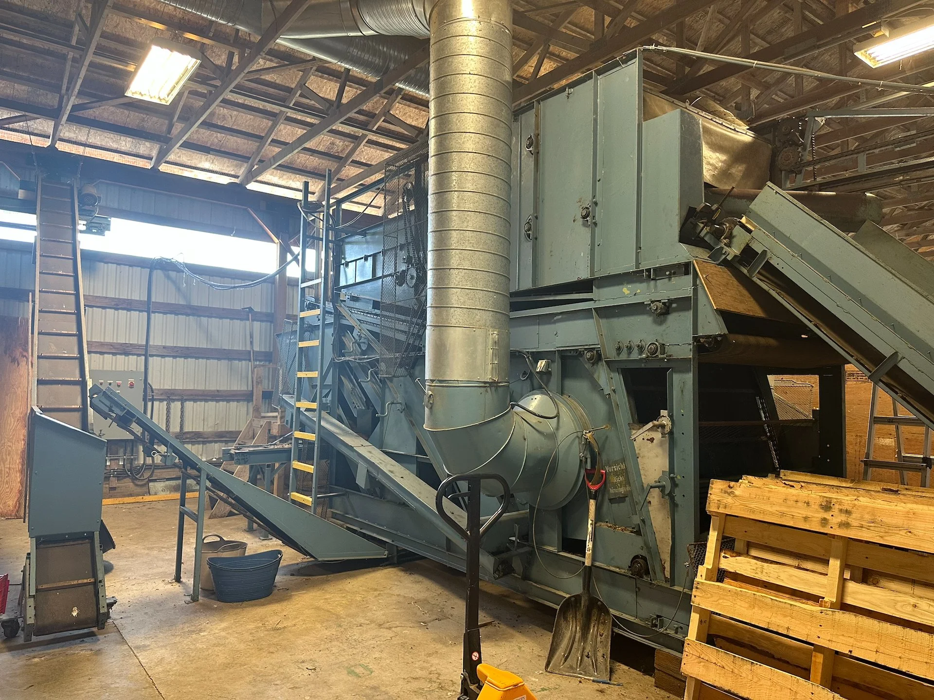  The thing is huge. After going through two levels of this beast, the hops are separated out and come out on the left, on the conveyor in front of the ladder. They then get taken up the second conveyor into the hop drying area.  