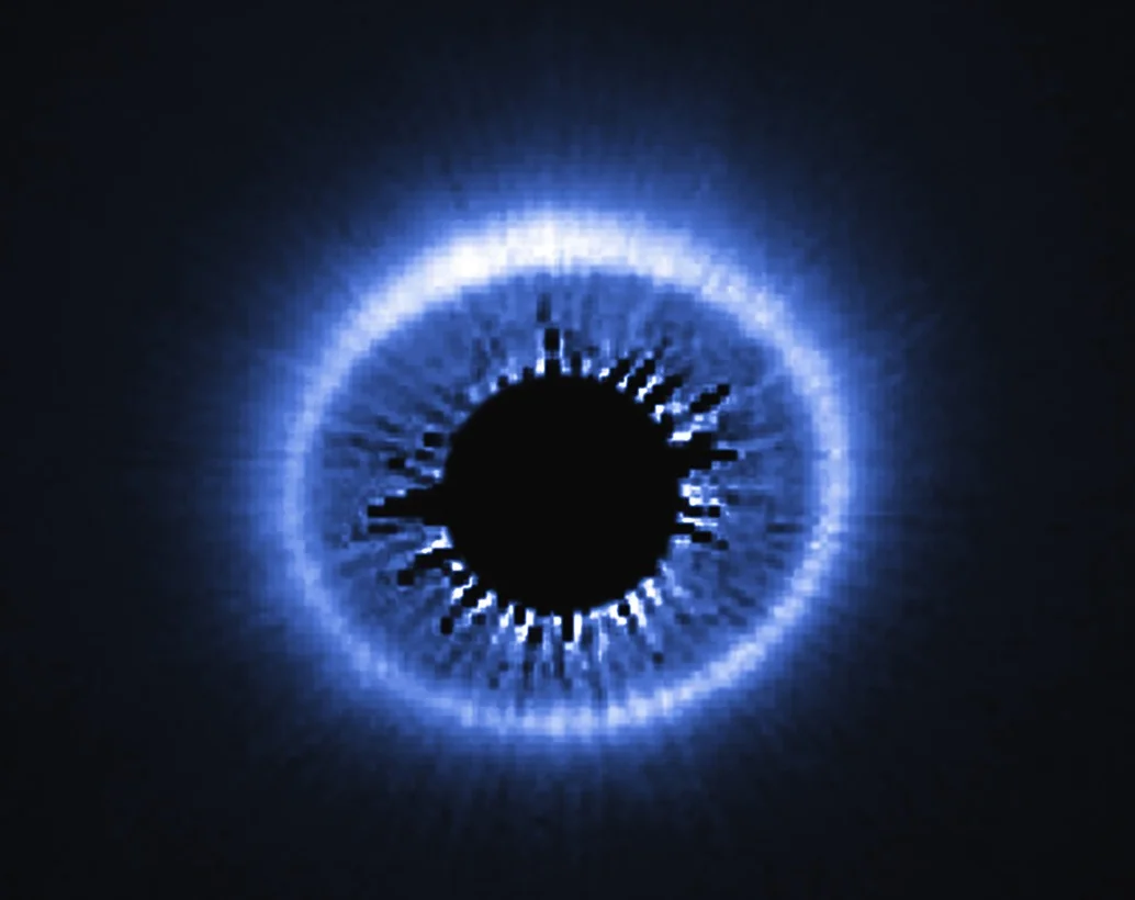 The infrared glow emitted by the disk of dust and debris surrounding a young star (masked in the center) may someday form planets. Source: Nasa/Esa/Univ. of Arizona/HST/GO 12228 Team