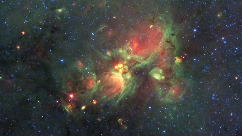 The yellowballs at the center of this image are glowing shells of gas surrounding newly born large, hot stars. Credit: Nasa/JPL-Caltech