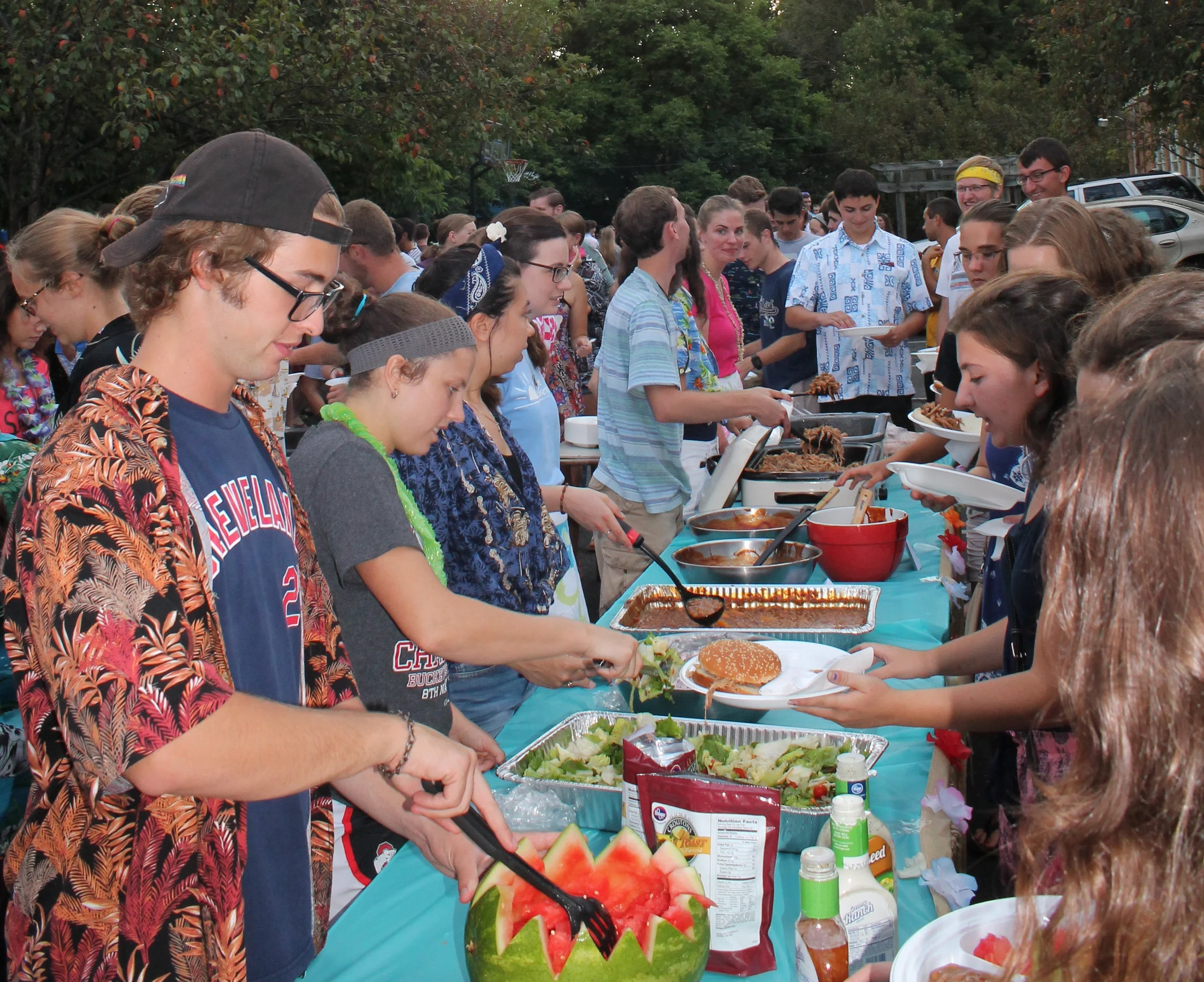 Jacob Ritchey (far left) helps serve food at SPO's annual Hog Roast. 