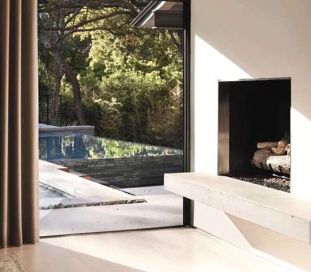 new concrete hearth and stainless steel surround added to existing fireplace… view from master suite to pool beyond