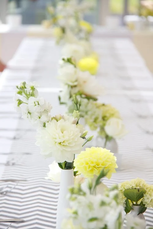 White wedding centrepiece table flowers in delicate tall vases