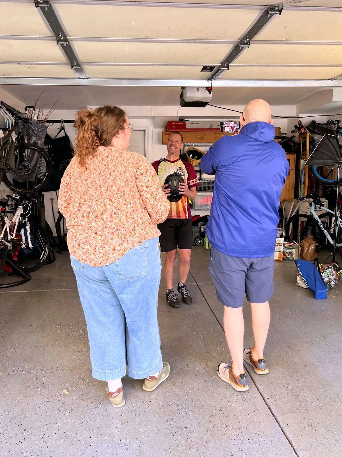 Behind the scenes photo of Kindle Point Founder and video director Kevin Gilsdorf, with Ride Illinois, Fundraising Manager Savannah Curry and Executive Director David Simmons during Bike Safety Quiz intro video capture in the garage shot