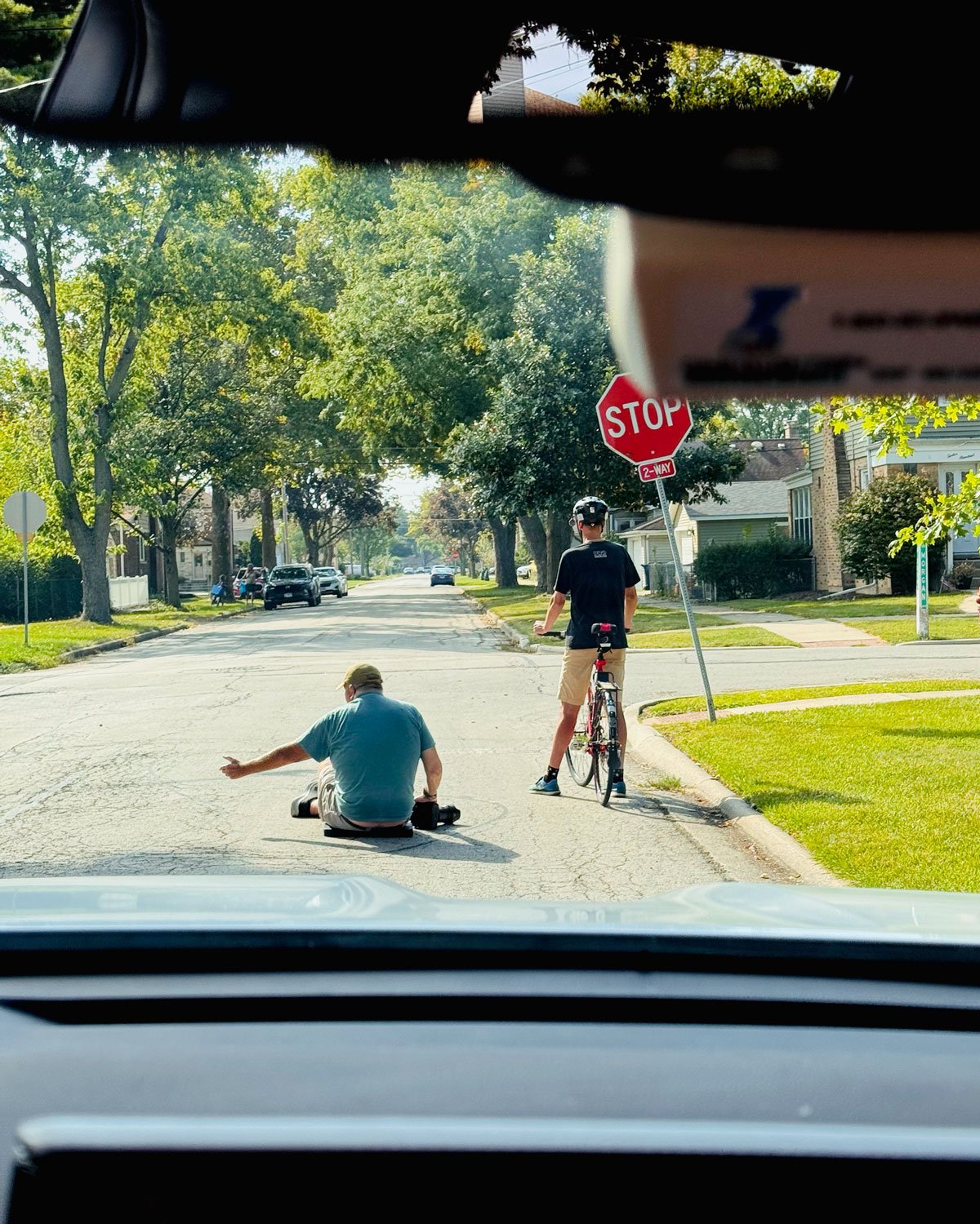 Behind the scenes capture of photographer sitting on the street to capture a dramatic upshot of a cyclists at a stop sign