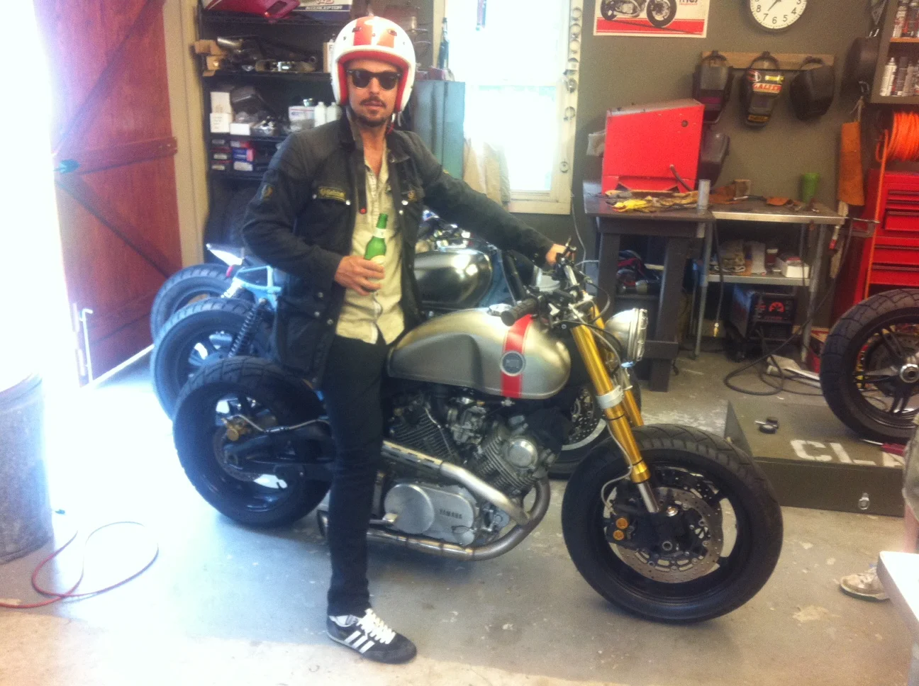 owner John experiencing some of the benefits of building motorcycles instead of working in advertising: Frequent social visits, no deadlines, honesty, American beer.