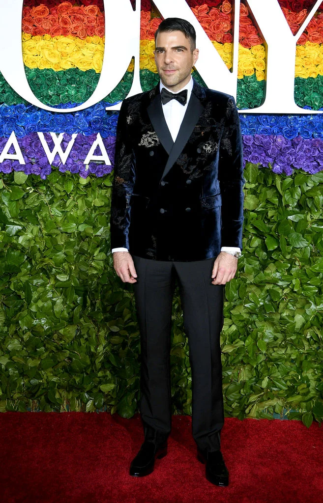 Zachary Quinto Partindo para um figurino mais chamativo e ainda muito bem coordenado, o ator americano optou por um blazer transpassado aveludado com bordados. Apesar de um pouco curto, o conjunto ornou perfeitamente por causa das peças lisas e discretas complementares.
