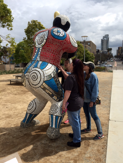 Ilse Cordoni, Consuelo Sierra, and Sherry Tobin examine Niki de Saint Phalle's "Baseball Player," on the San Diego waterfront.