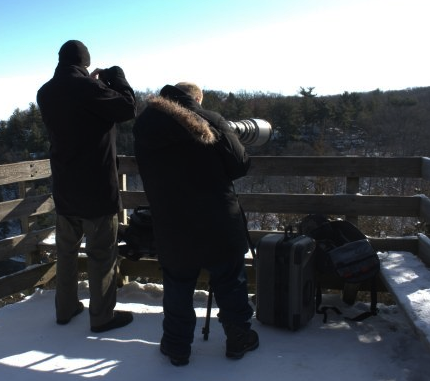 Bald Eagle Photography with a Compact Camera . That’s me and my buddy Tom snapping pics of Bald Eagles at Starved Rock State Park. OK, so it’s ridiculous for me to attempt this with a compact camera. But that’s kind of my point - I don’t really care about Eagle photography. If I did, I would have the kind of set up Tom has. Instead, as he took his time setting up that gigantic lens, I walked around inspecting the rocks, ice, snow, shadows and patterns for photos I found compelling. To each his own. And, yes, we both brought back pics we were proud of.