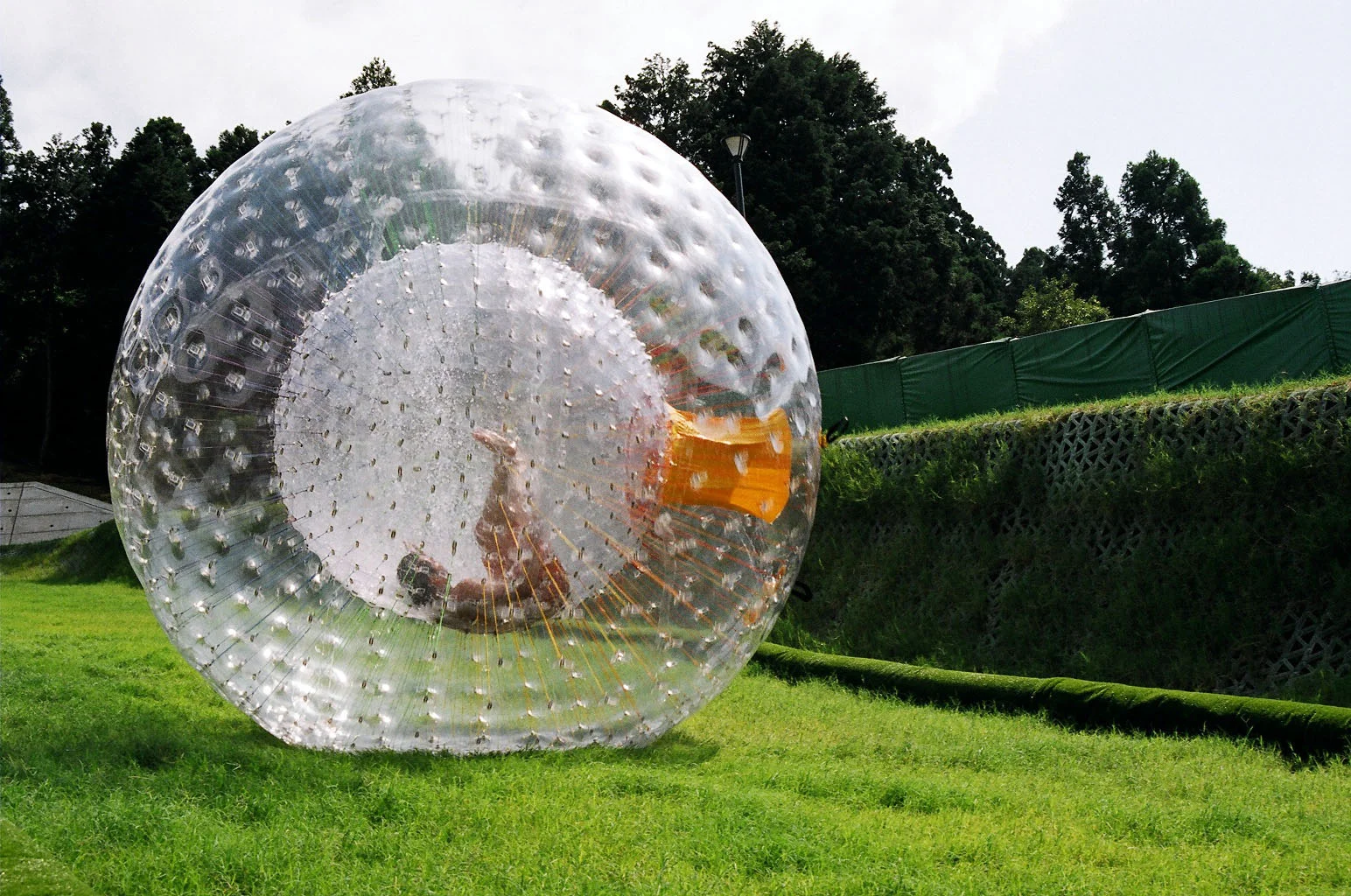 Zorbing is a sport in which a participant is secured inside an inner capsule in a large, transparent ball that is then rolled along the ground or down hills. It's one of the thrill seeking activities that Mike A has done....swimming with sharks is on his "to do" list