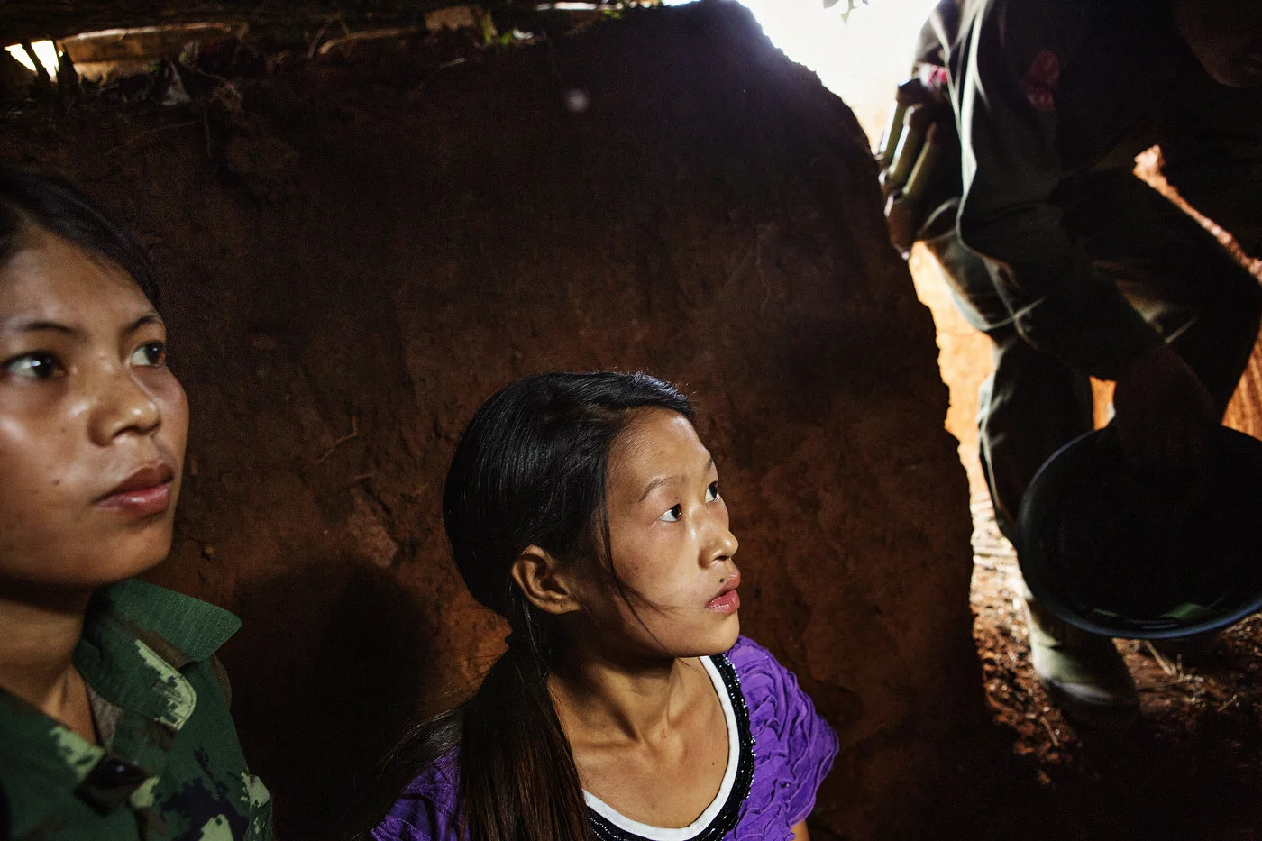 Two female Kachin
Independence Army (KIA) medics take cover in a bunker as Burmese jets are approaching
in the distance December 30, 2012 close to the small town of Namsangyang. In
recent days, the Burmese Army has deployed helicopter gunships and fighter
jets. 