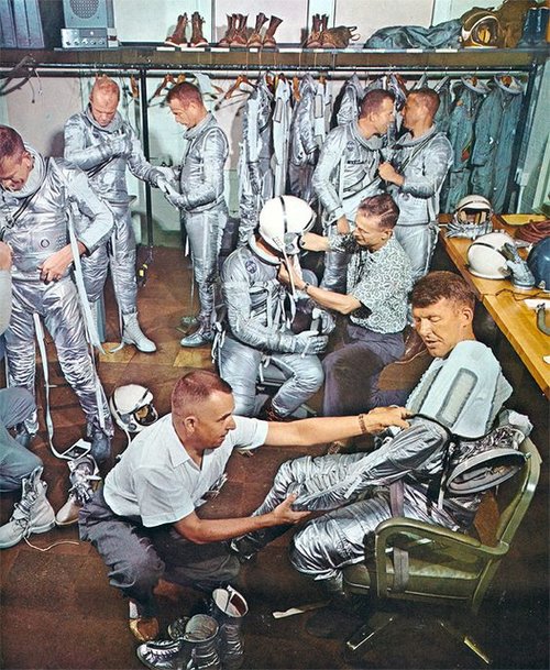 The Mercury 7 in a fitting for their Mark IV space suits. Note the sage green option for the suit in the back right.
