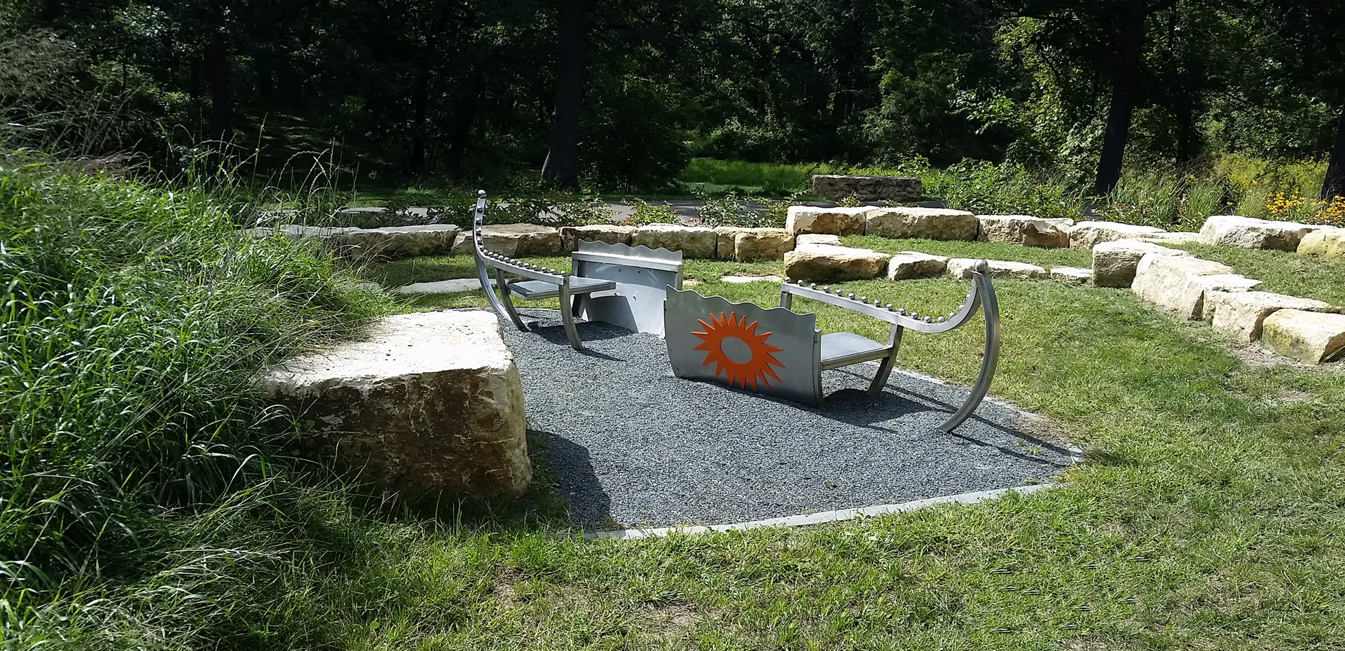 Sculptural canoe, ampitheater, story stone and viewing hill with native plantings. Public commission by Cox, Lunning, Calderaro.