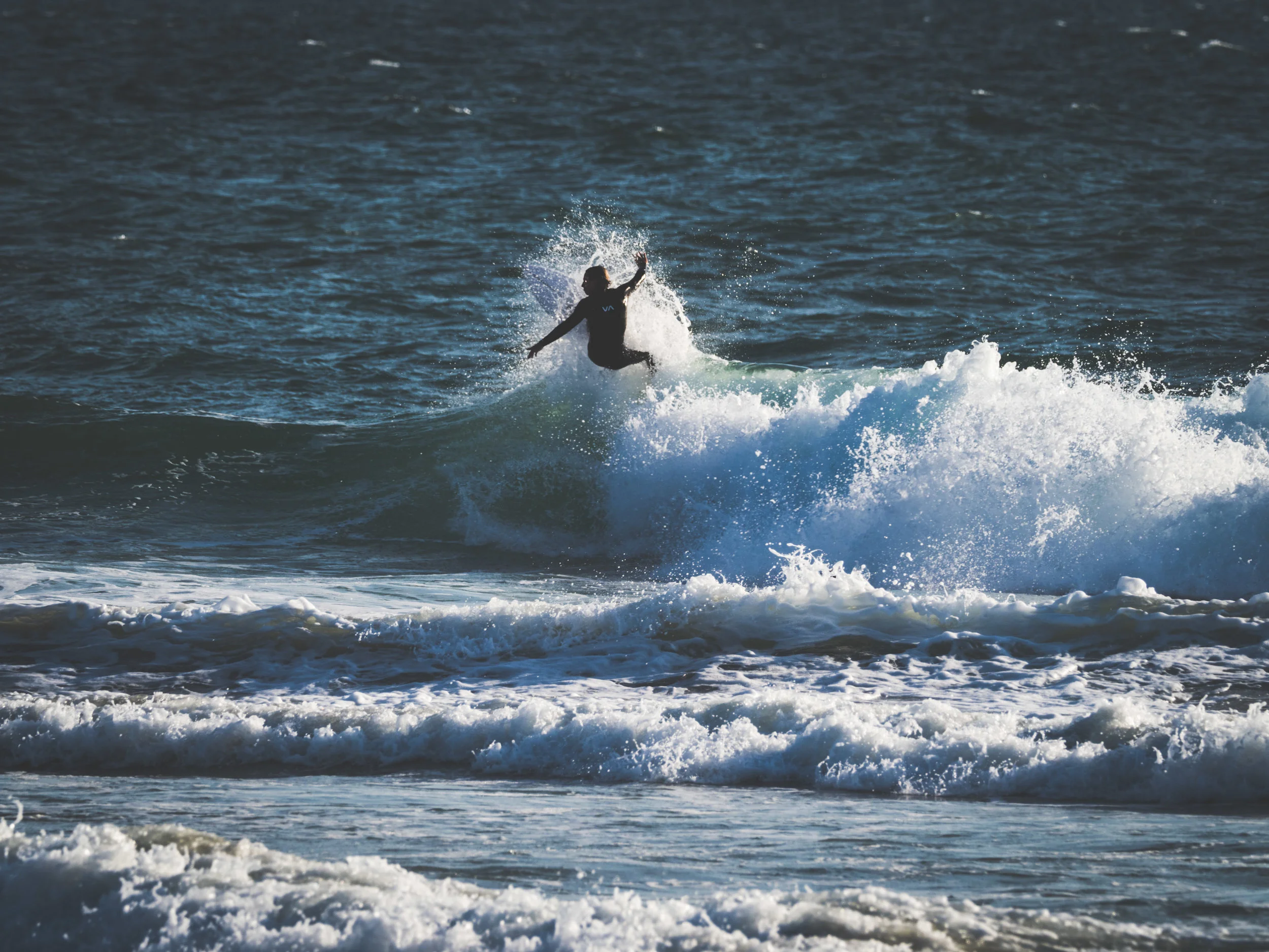 A Huntington Beach surfer slashing the surf. Shot w/ the Olympus OM-D E-M1 MkII + 300mm f/4 PRO + MC-14 Teleconverter .