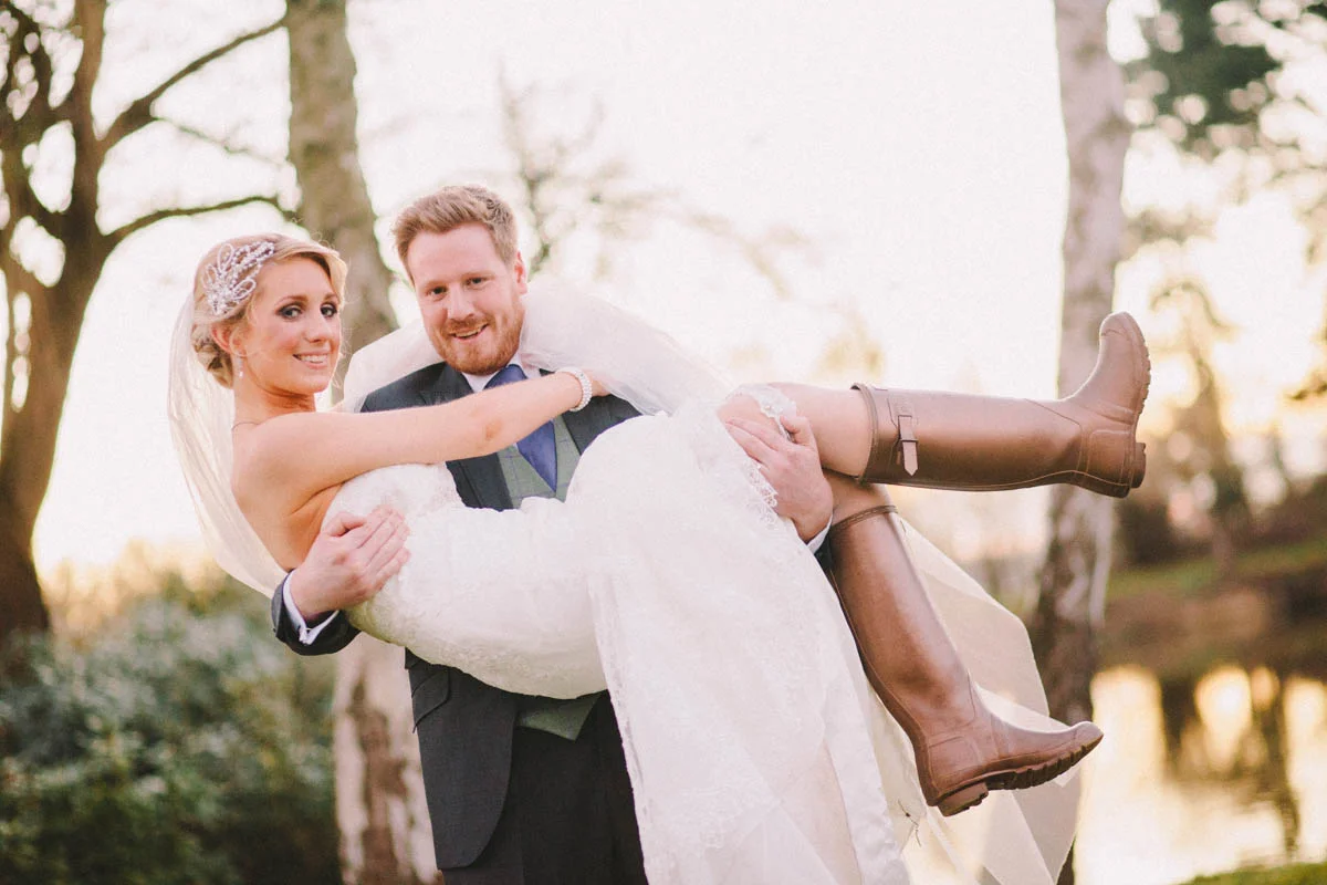 A Groom Carries his Bride At Sunset by a Lake.jpg