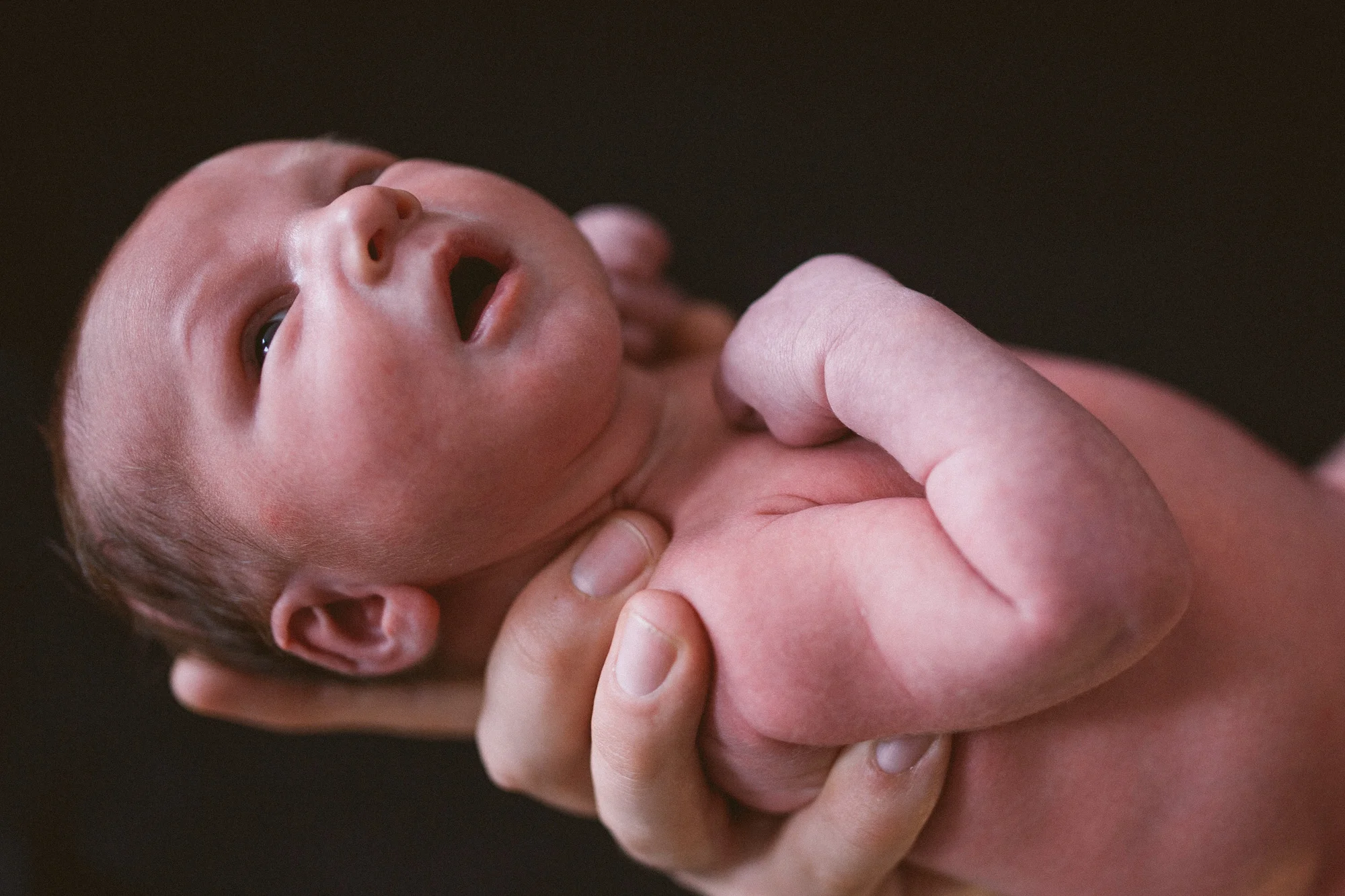 A baby is held in her mother's hand.jpg