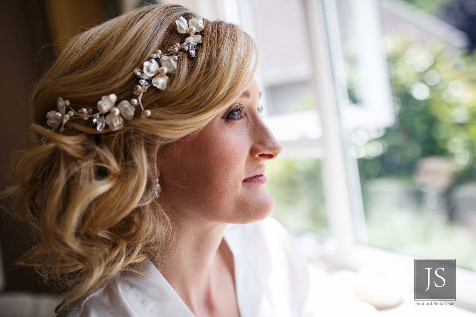 A serene bride to be waits with her hair and makeup done.jpg