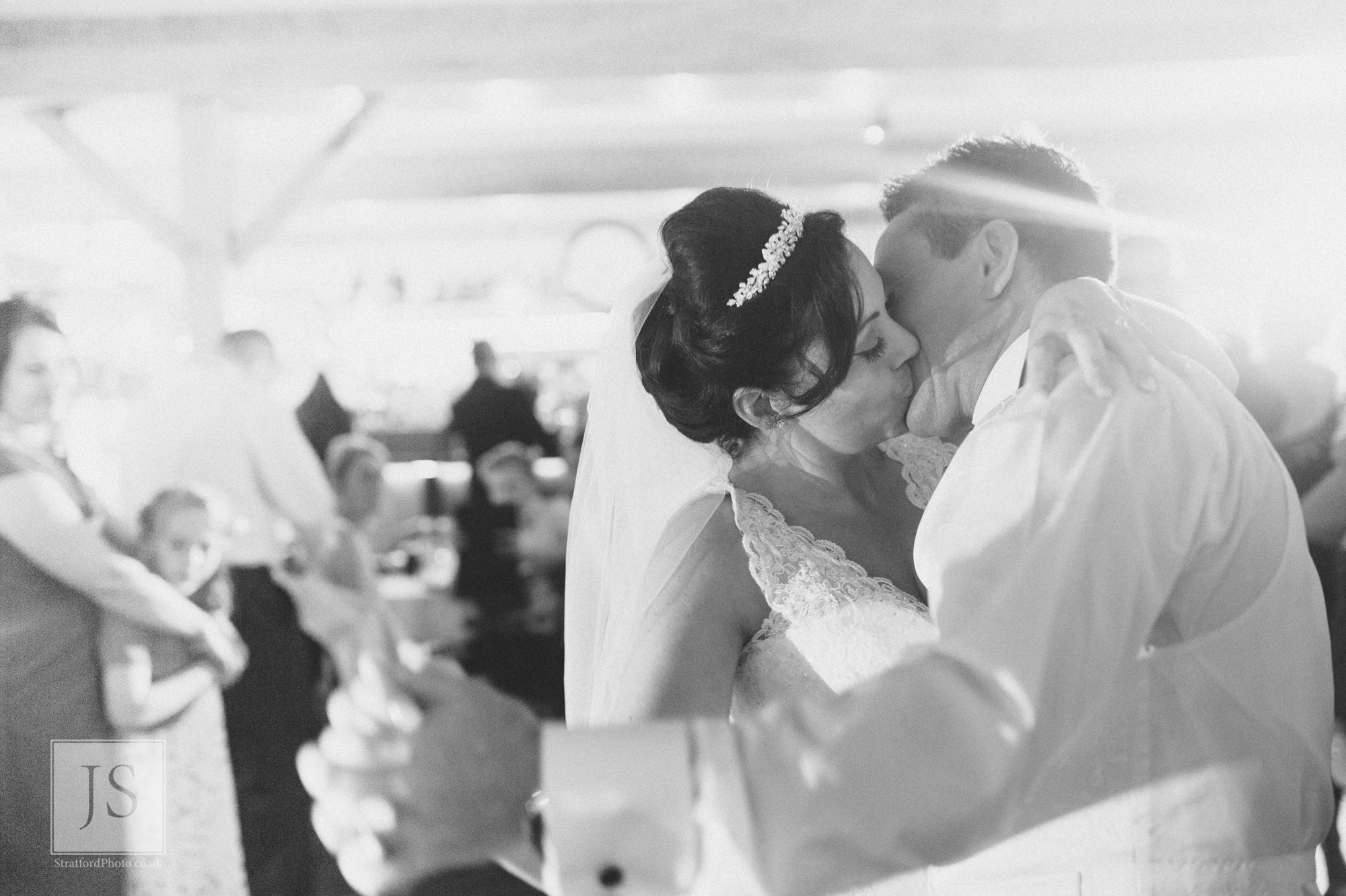A bride and groom kiss passionately during their first dance.jpg