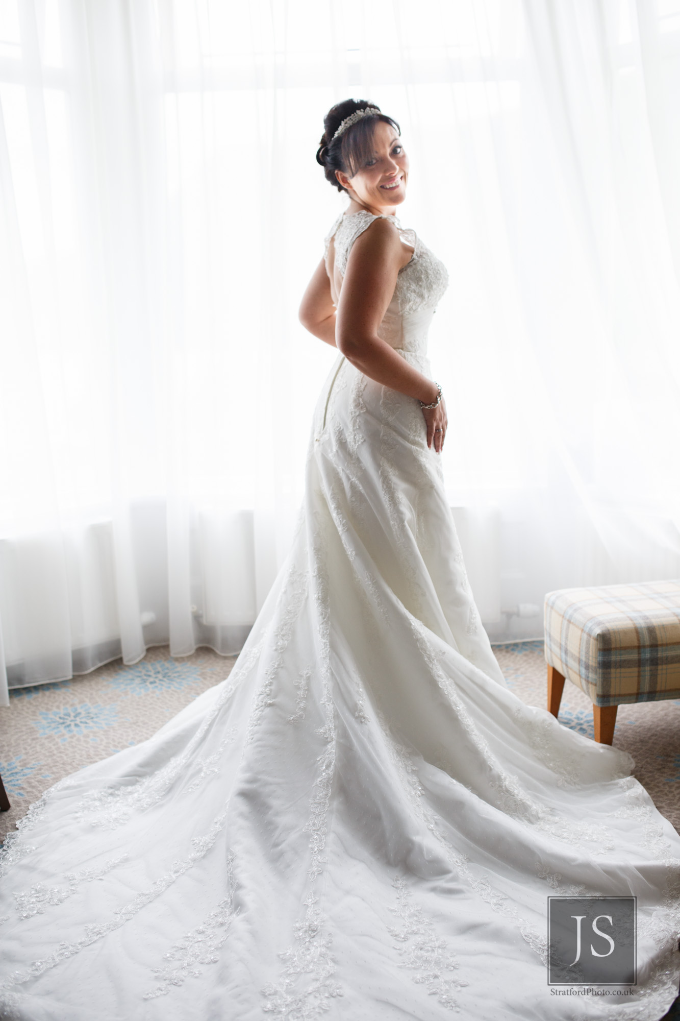 A bride delights in her dress as the train is laid out on the floor for the first time.jpg