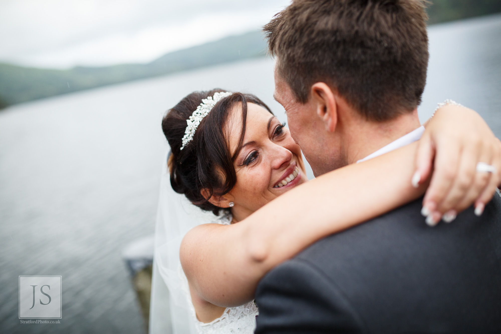 A bride smiles as she looks into her gooms eyes at Lake Ullswater.jpg