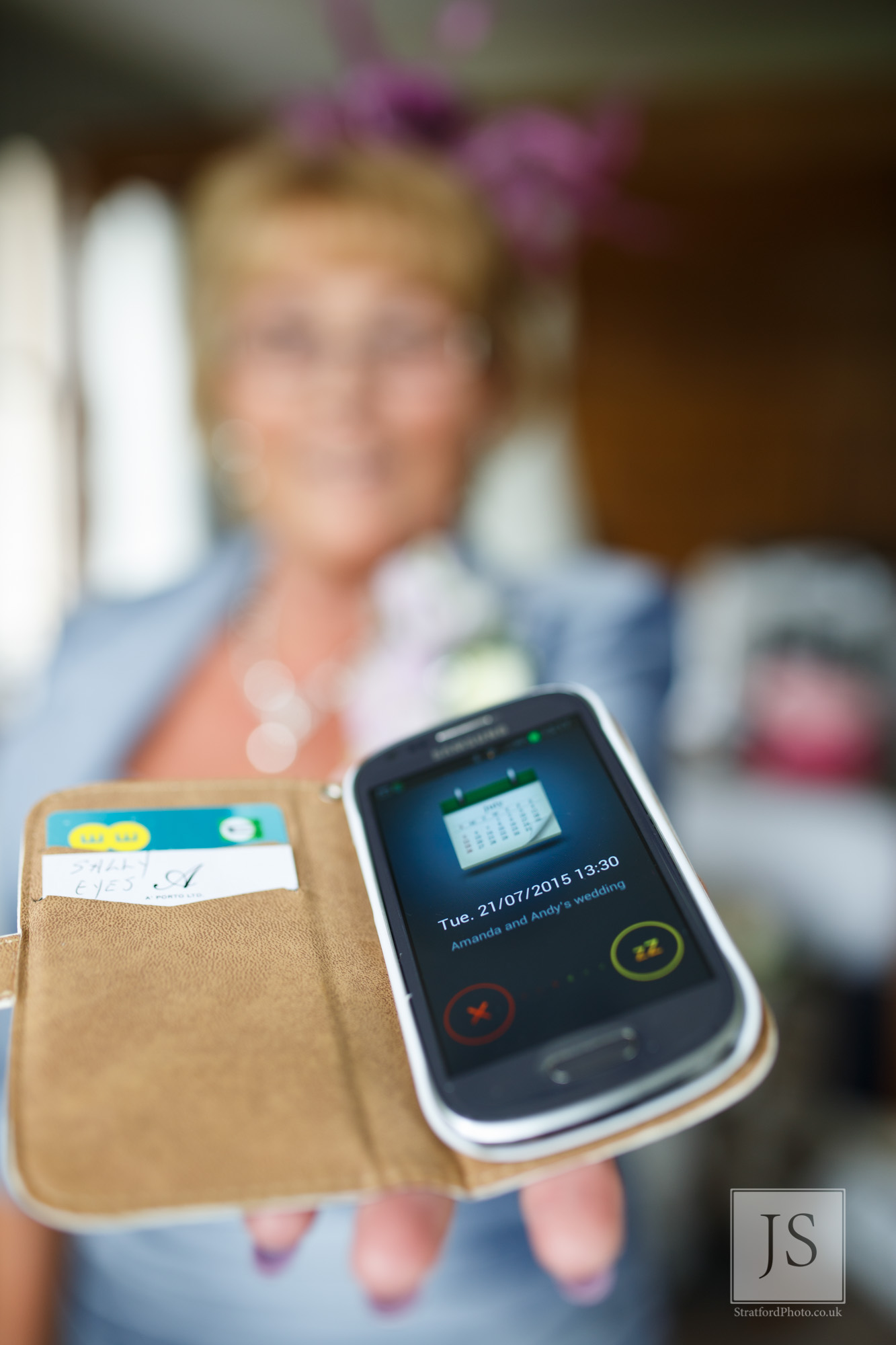 The mother of the bride holds out her phone with the calendar showing ther wedding date.jpg