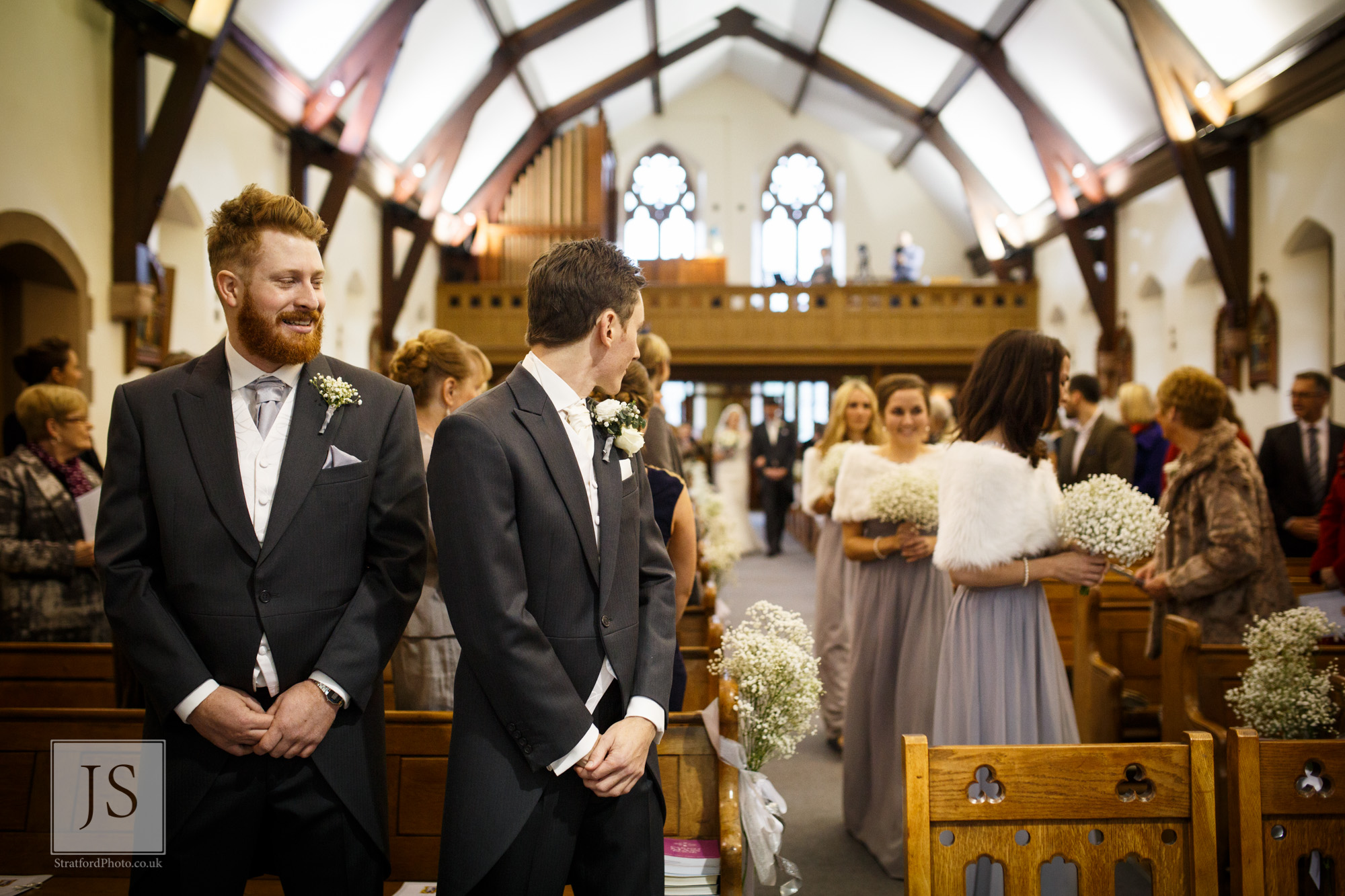 A nervous groom waits for his bride to come odwn the aisle.jpg
