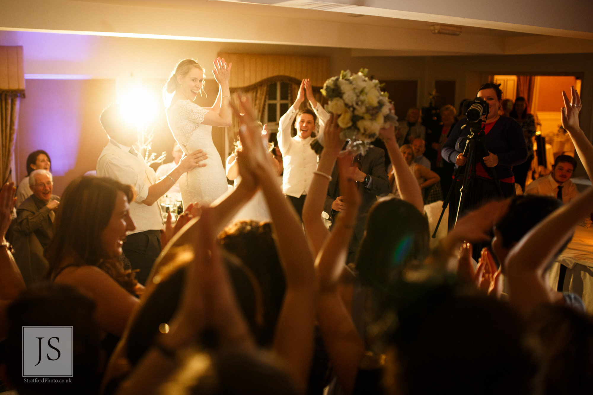 A bride throws her bouquet across the dance floor at Leasowe Castle.jpg