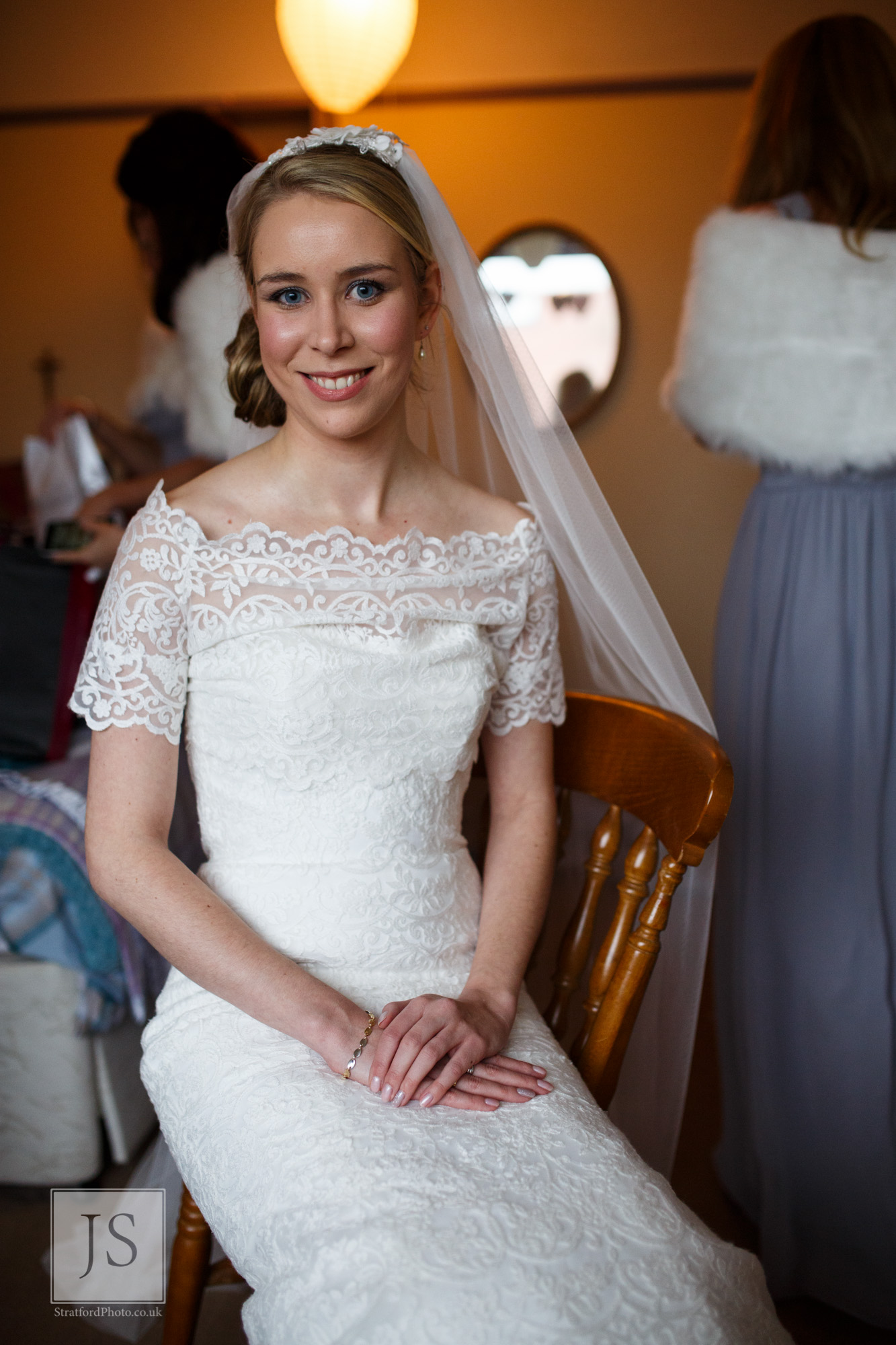 A bride sits happily waiting for her car to arrive.jpg