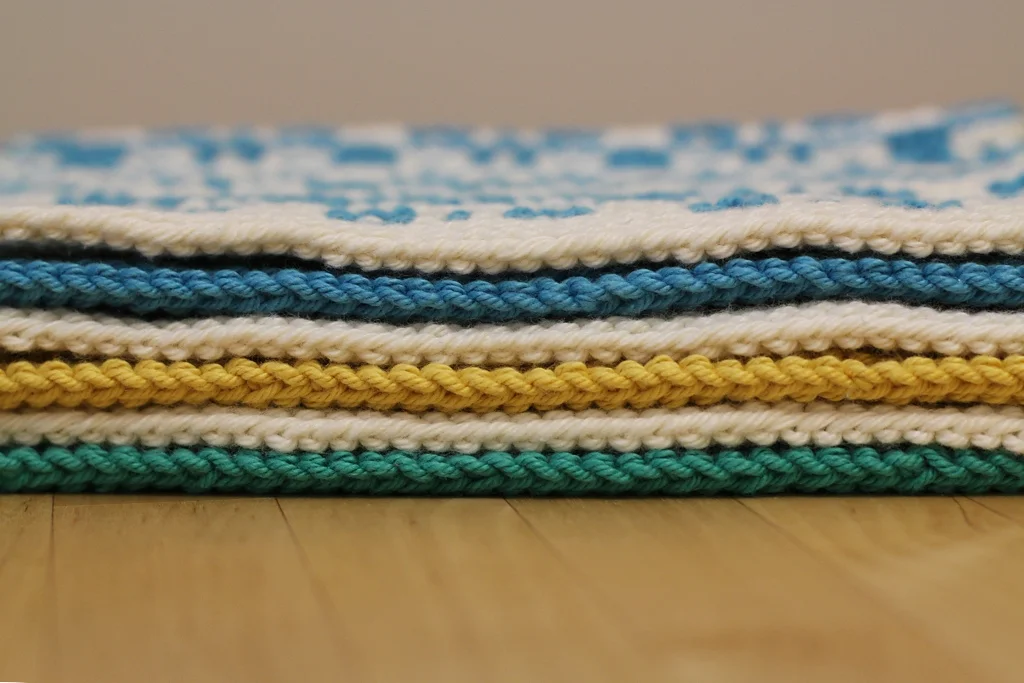 Colorful and geometric, the Mosaic Sisters are textured mosaic knit cloths perfect for the kitchen or the bathroom. Each cloth is made with garter stitch and slipped stitches that are simple to knit, but create complex patterns. All of the sisters can be made as a kitchen towel, washcloth, or coaster. Make a full set in 2 colors or mix and match.