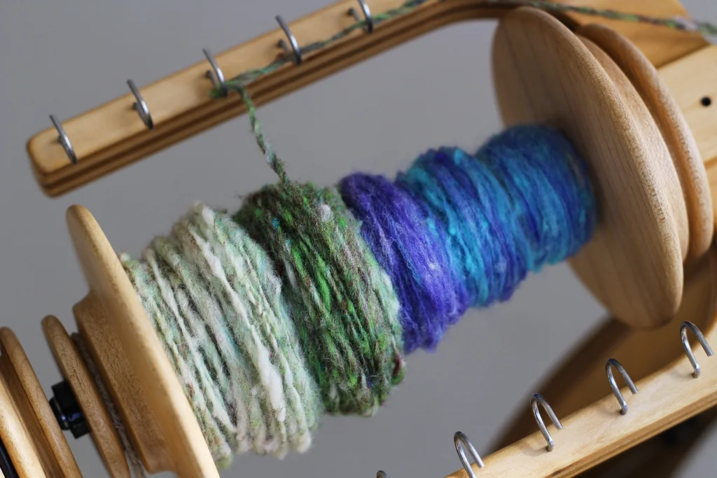 The blue and purple is what the single looked like when using the first drafting method. The green and white used the second drafting method. | Spinning Noro Rainbow Roll Part 1 - withwool.com