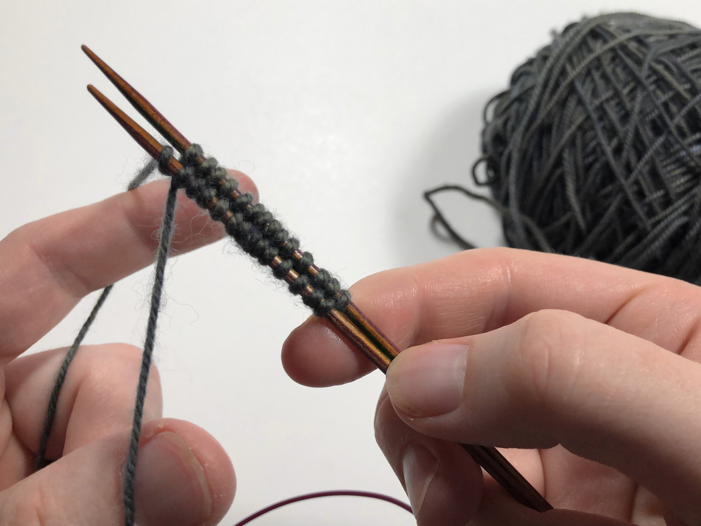 Learn how to work Judy’s Magic Cast-On to seamlessly start knitting in knit or purl. It’s a great cast-on to use for toe-up socks and other projects that start from the center out. #knitting #knittingcaston #knittingtutorials | withwool.com