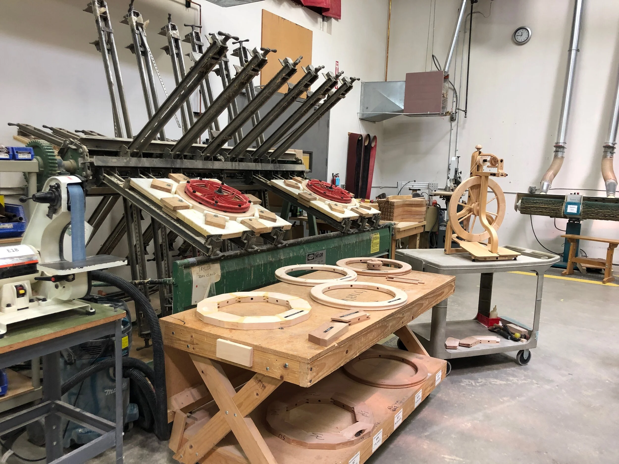 The machine used for making wooden wheels, a table showing wheels at various steps in the process, and a finished wheel on display. Celebrating Schacht’s 50th Anniversary || withwool.com #schacht50years