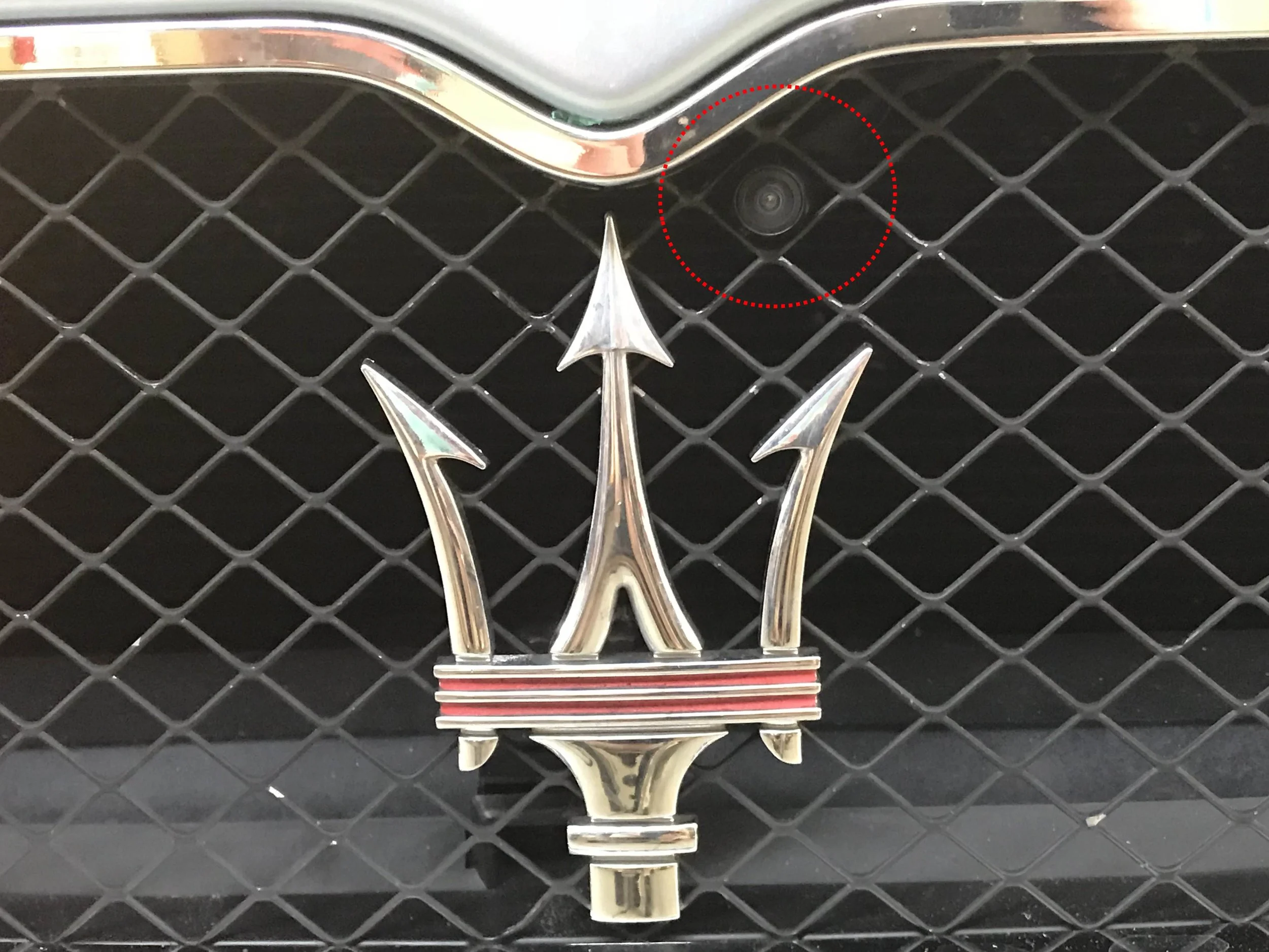 Highlighted in red above the trident in the grille, the camera looks straight out in front of the car without being noticeable