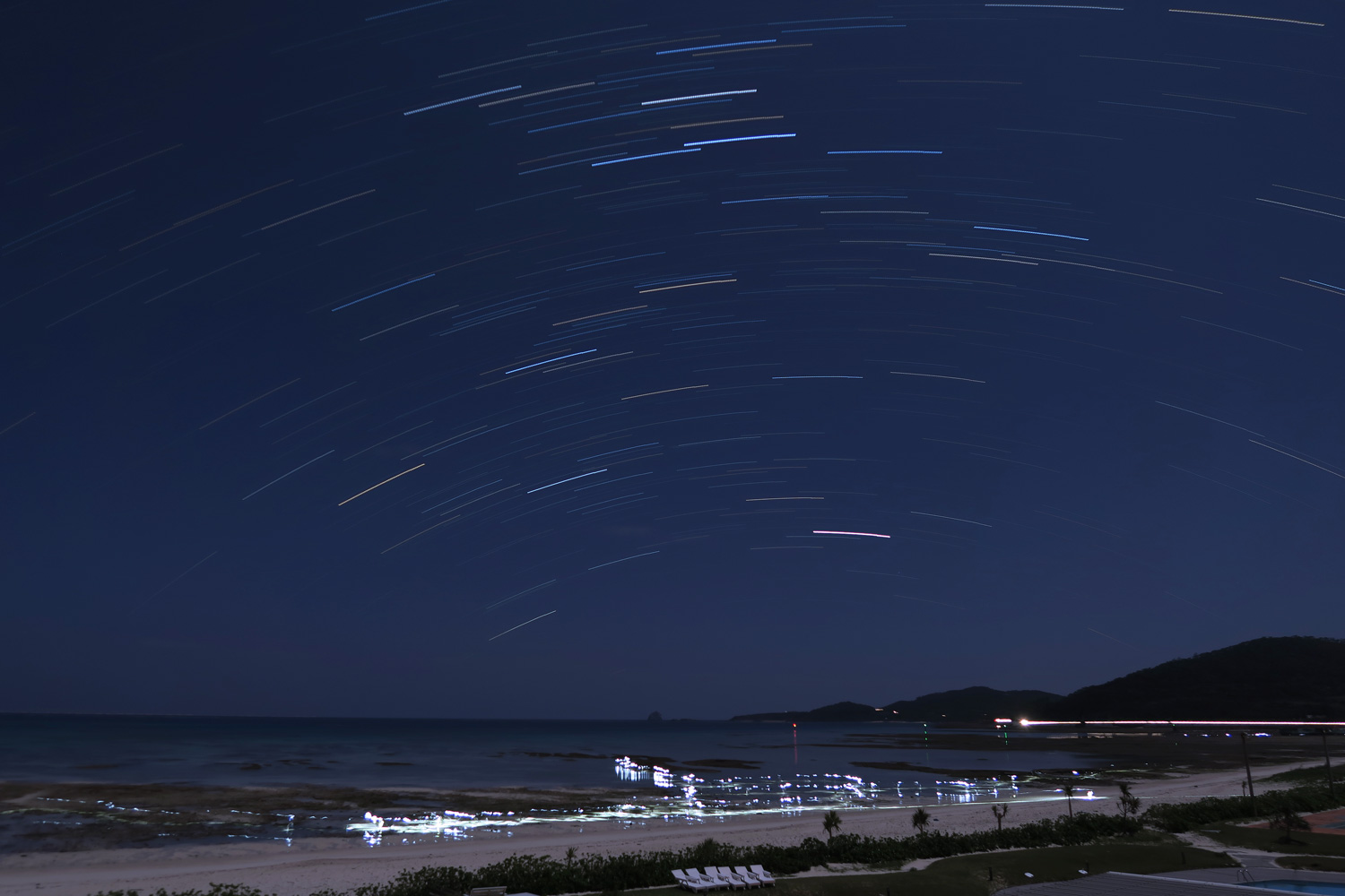 30 minute star trail exposure with people looking for crabs with flashlights at 2:00am.